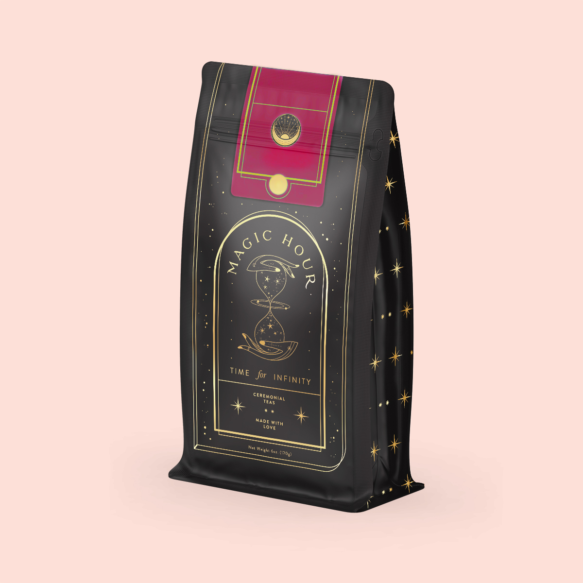 The Soulmate Chocolate-Raspberry-Rose Black Tea refill pouch features a celestial black and gold design labeled "Magic Hour, Time for Infinity." It includes an hourglass and stars, evoking wellness rituals. A red and gold top contrasts elegantly with the soft pink background.