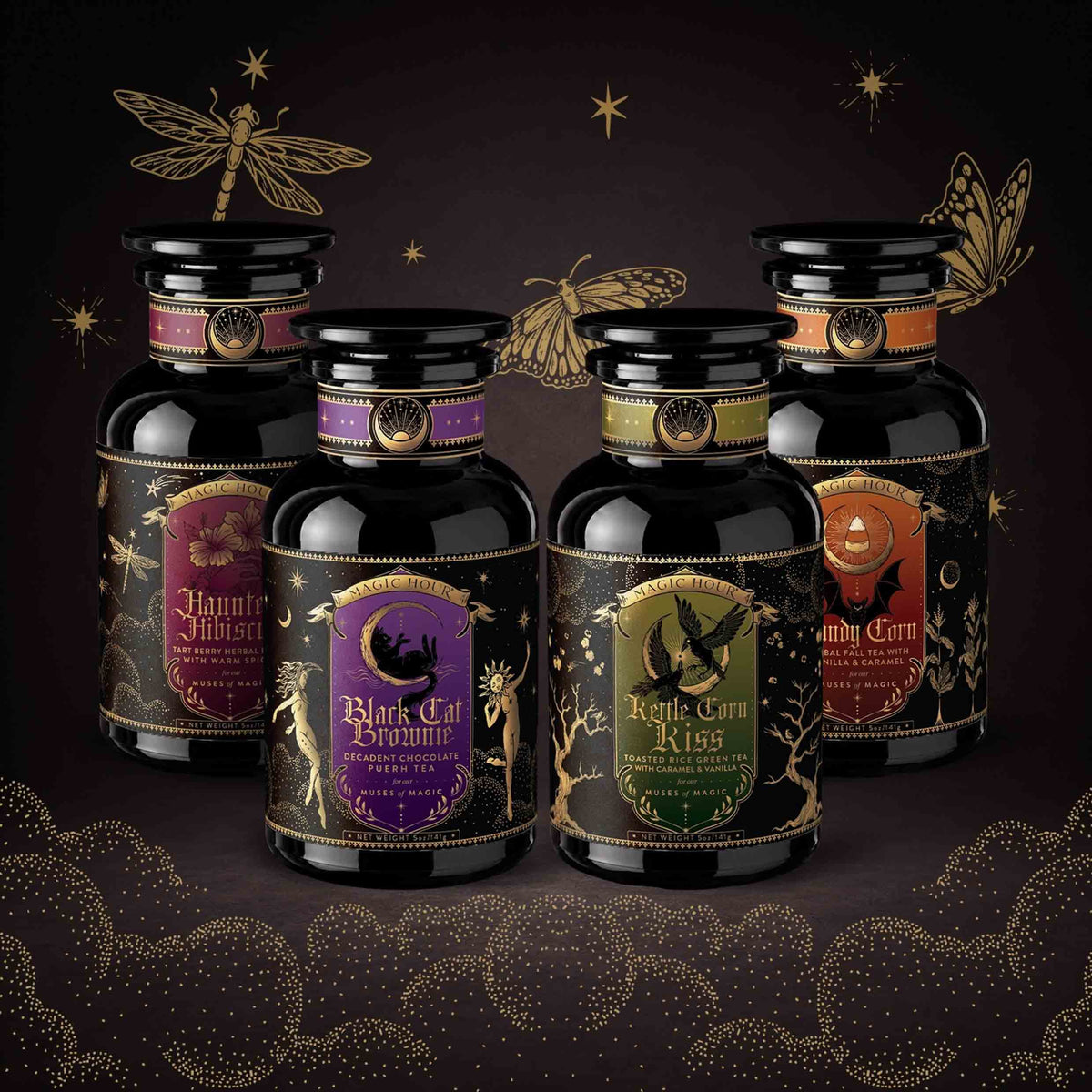Four glass jars from the Spellbound Sips Bundle arranged in a semicircle, featuring ornate black labels with gold illustrations and text, set against a dark background with gold star and butterfly accents.
