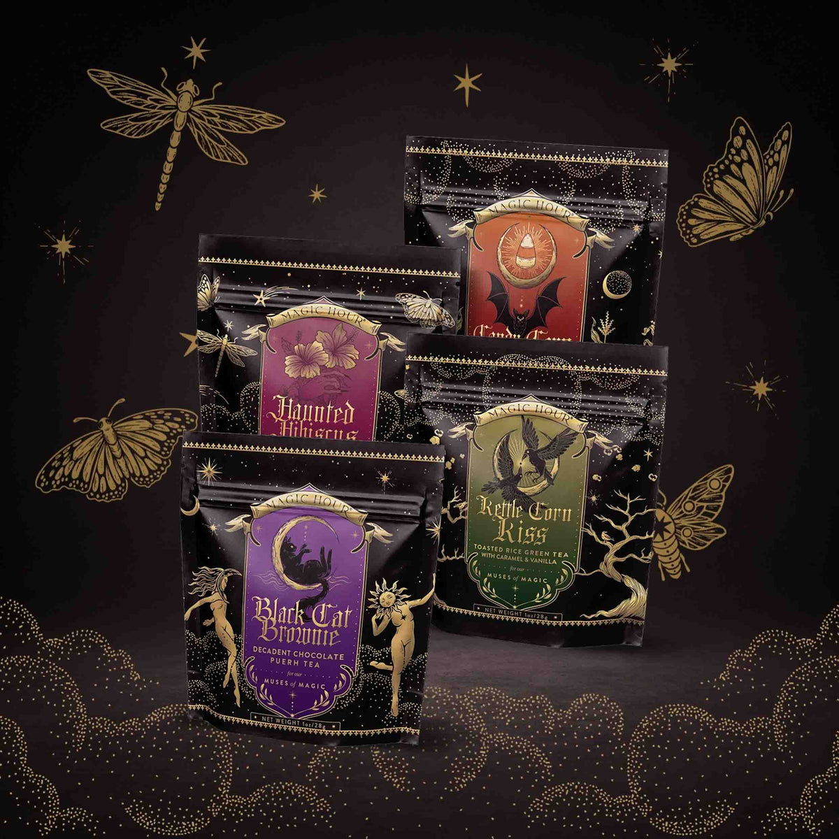Four black pouches of Spellbound Sips Bundle tea, decorated with gold celestial and nature illustrations and labeled “Haunted Hibiscus,” “Candy Corn,” “Kettle Corn Kiss,” and “Black Cat Brownie.”.