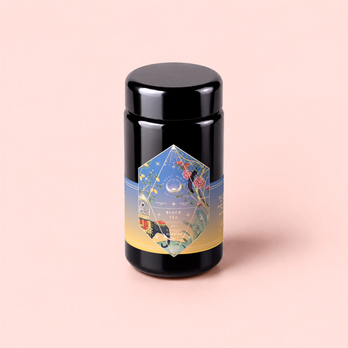 A canister of Sri Lankan Sunrise, featuring a colorful geometric label with nature-inspired illustrations, sits atop a soft pink background. This elegant container holds organic black tea—an ideal choice for savoring as a classic Sri Lankan breakfast brew.