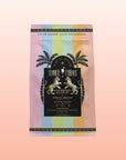 The Summer Fridays™: Strawberry Daiquiri tea features a vibrant package with palm trees and a sunset gradient, pairing mocktail-inspired green tea and low caffeine for a delicious, summery sip.