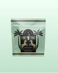 A pastel green resealable pouch labeled "Summer Fridays™: Mojito Mint" with a black and gold circular logo, palm trees, and zebras contains this peppermint green tea—a zero-proof cocktail in a cup by Magic Hour.