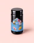 Summer in Amalfi is a black tea canister adorned with a blue label featuring vibrant fruit and floral illustrations, set against a light pink background—this charming tin evokes the refreshing flavors of Amalfi Coast tea, with notes of lemon bergamot and delicate organic oolong.