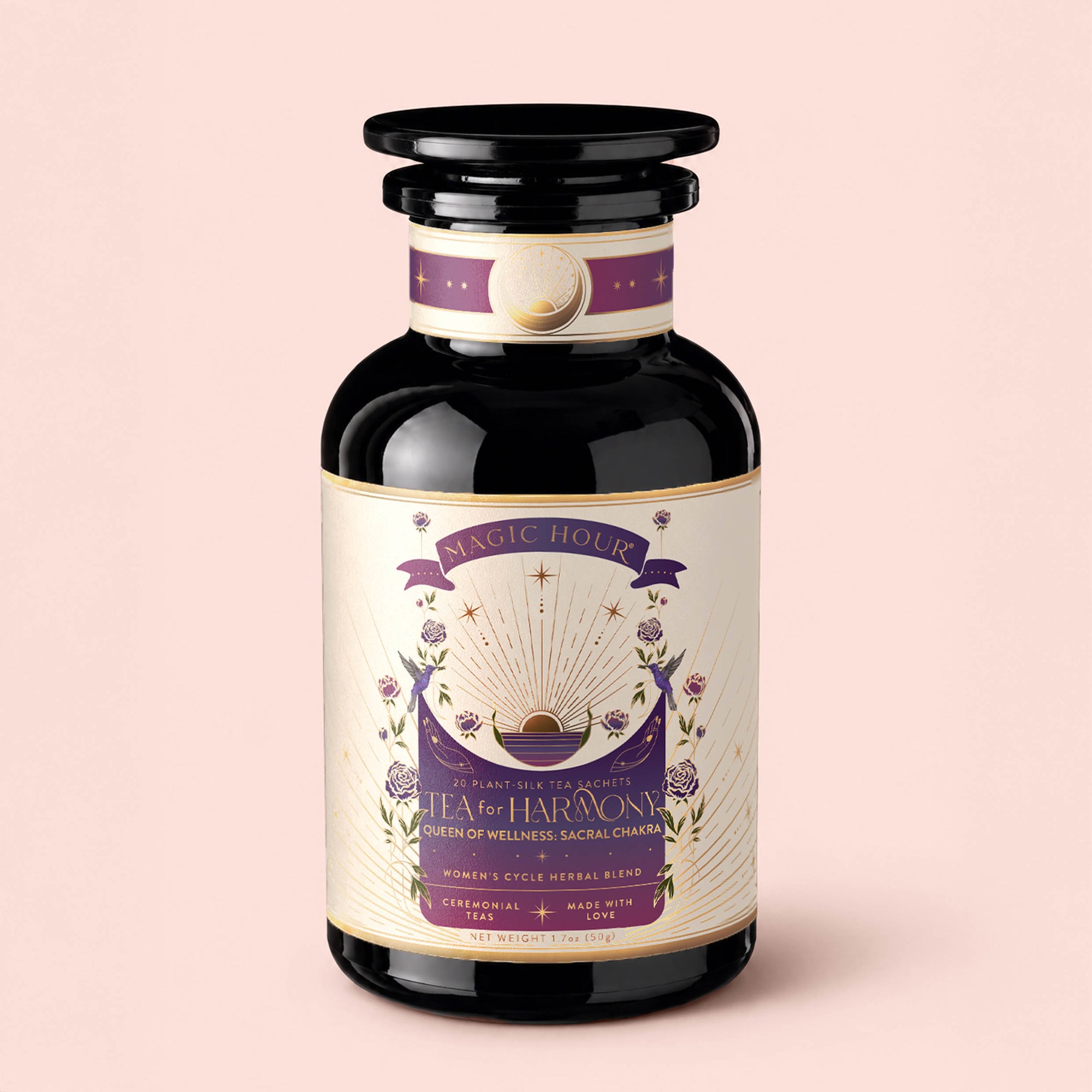 A dark glass jar labeled "Tea for Harmony: Queen of Wellness: Women's Cycle Herbal Blend" with purple, gold, and white design elements—including sun rays and flowers. The jar features a wide black lid and has a decorative, mystical appearance—perfect for women's herbal tea blends such as raspberry leaf or soothing organic chaste berry infusions.