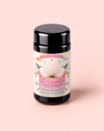A black canister labeled “Tea for Compassion: Ti Quan Yin: Organic Oolong Tea,” featuring a pastel design with sun rays, hands, and a heart on a pale pink background—ideal for storing your favorite original style oolong or fermented oolong tea.