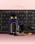 The Tea & Honey Gift Set features a dark purple bottle, wildflower honey with a gold spoon, and a black star-patterned box with ribbon—an elegant choice to elevate your morning ritual on a pink, softly shaded background.