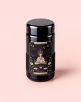 Introducing The Oracle: Lemon Lavender Tea for Supporting the Gut-Brain Axis—a beautifully designed black tea canister featuring an illustrated label with a meditating figure surrounded by stars, plants, and mystical designs on a soft pink background. Perfect for storing your favorite adaptogenic or caffeine-free herbal tea blends.