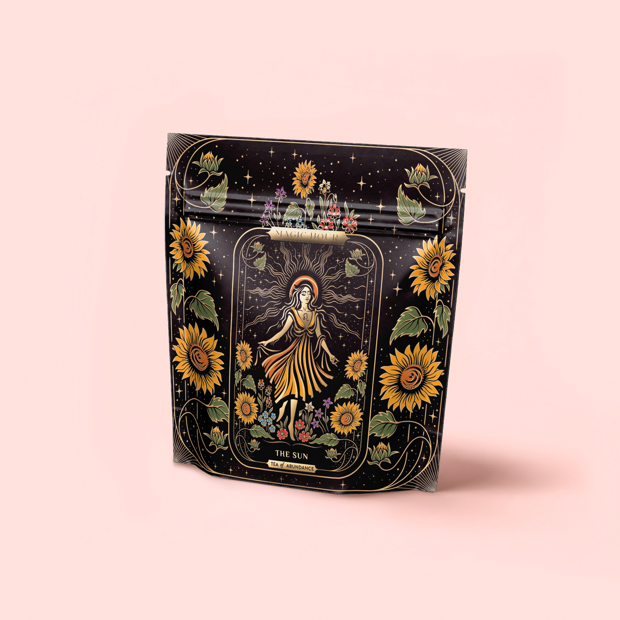 A black package with sunflowers and a central figure in a yellow dress, surrounded by rays and flowers. The label says "THE SUN." Shows off The Sun: Energizing Adaptogenic Herbal Tea with Yaupon, Moringa & Turmeric on a soft pink background.