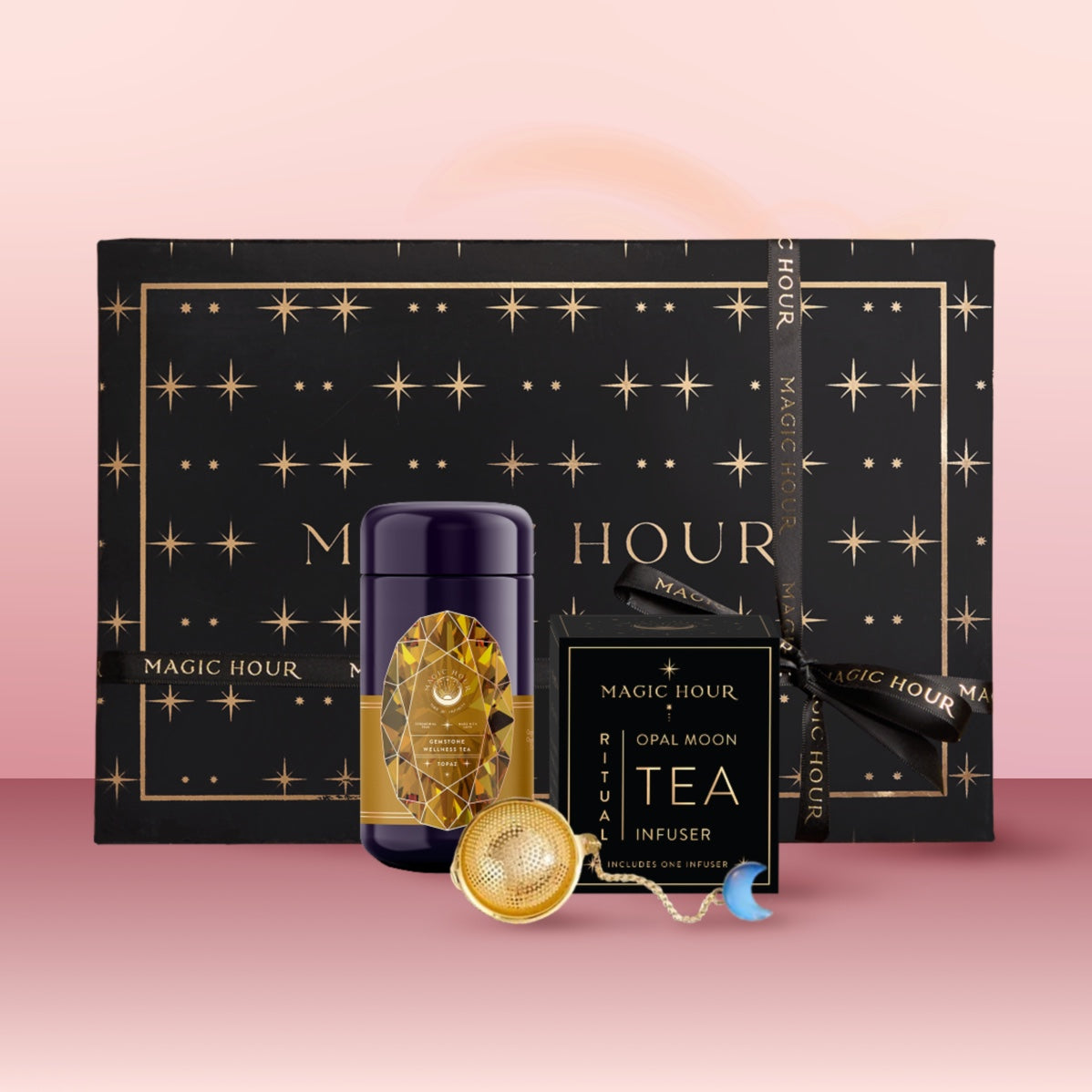 The Topaz November Birthstone Mini Gift Set features a black and gold starry box, a purple "Topaz Wellness Tea" tin, an "Opal Moon Tea Infuser," and a gold infuser with blue charm—perfect for November birthdays.