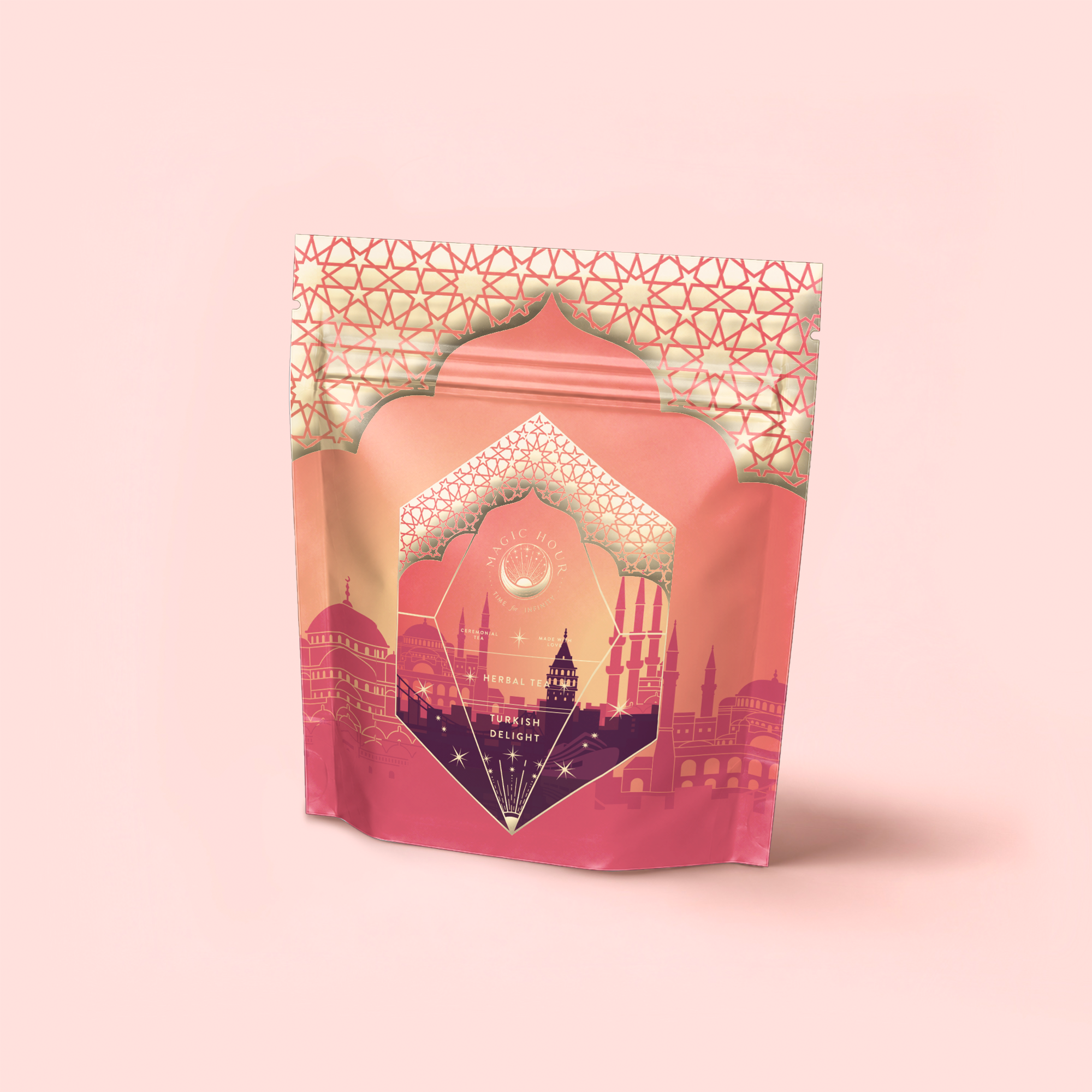 A pink and gold resealable pouch with Middle Eastern geometric patterns and cityscape art, labeled “Turkish Delight,” features a calming, caffeine-free herbal tea blend, set against a soft pink background.