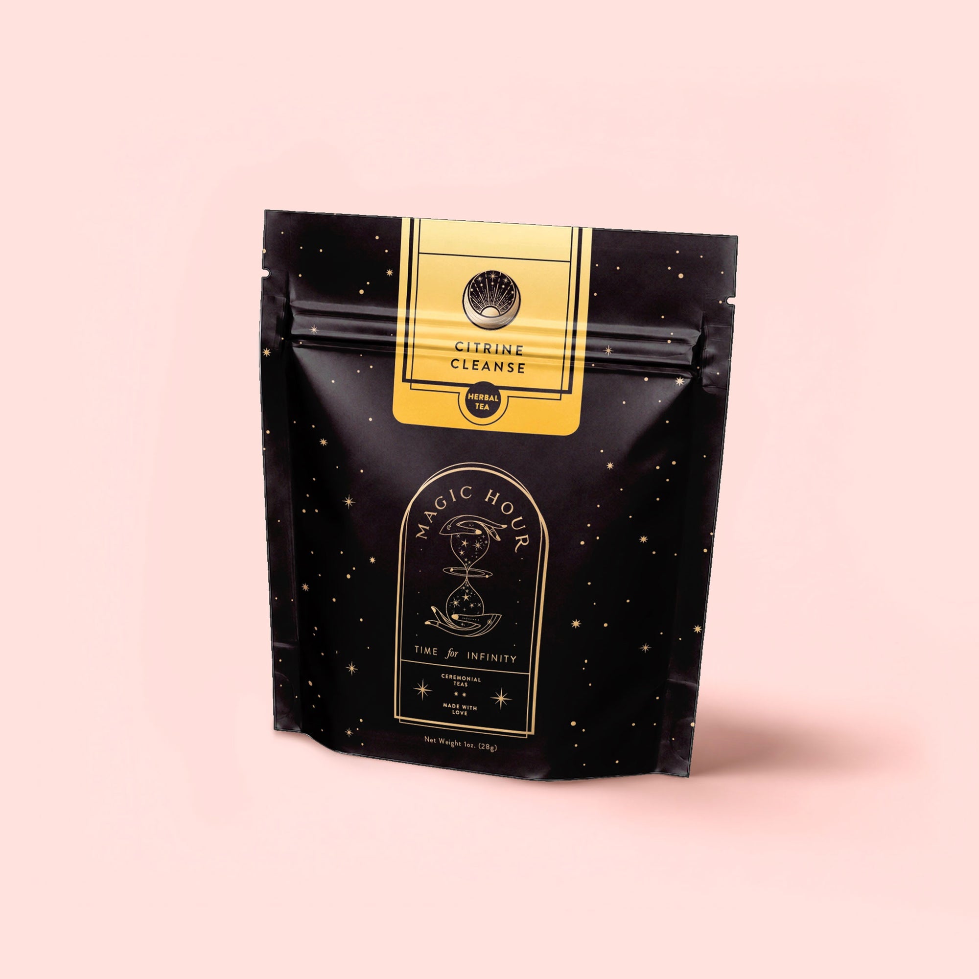 A black stand-up pouch labeled "Magic Hour" with gold stars and text displays Citrine Cleanse™ Herbal Tea, a caffeine-free detox blend, set against a pale pink background.