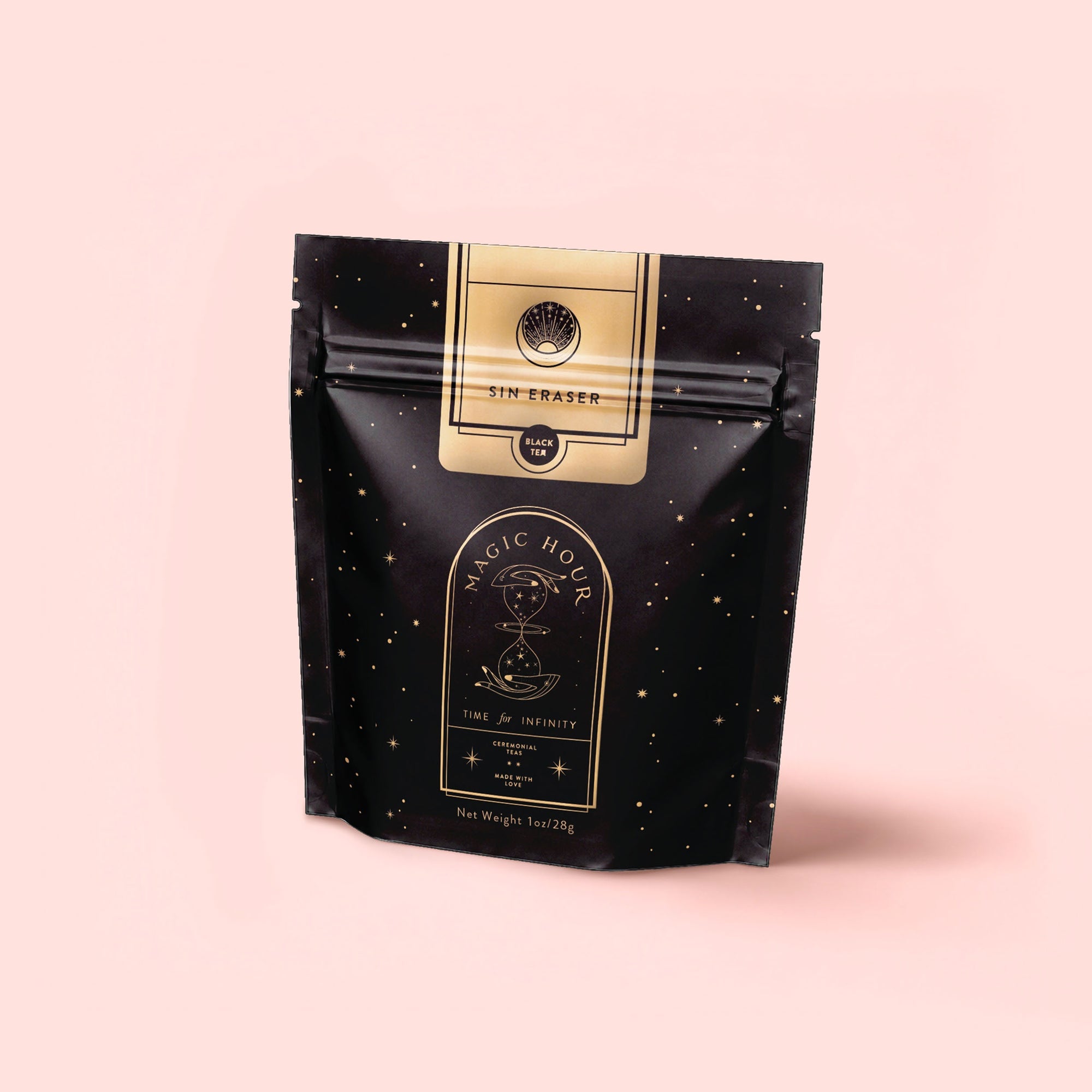 A black resealable pouch with gold celestial designs and "Sin Eraser™: Puerh Tea" stands against a light pink background. The starry, elegant packaging hints at the vintage puerh tea blend inside.