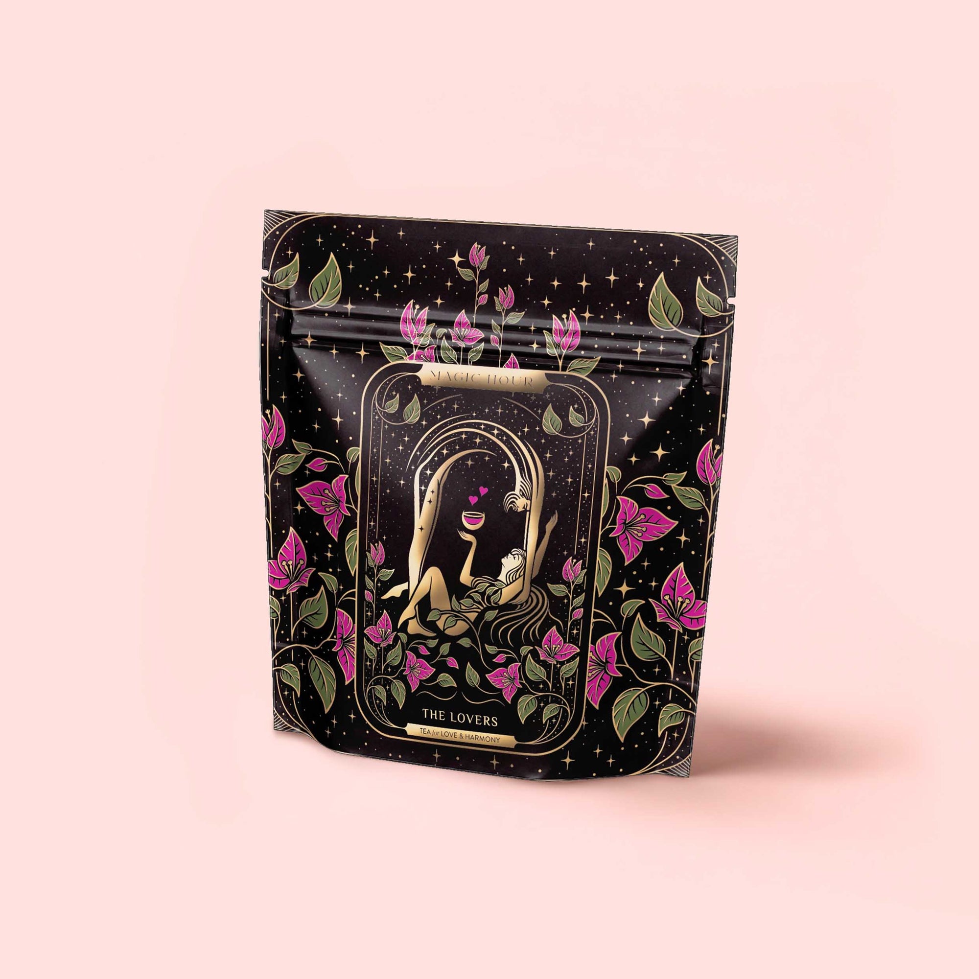 A decorative black pouch with floral designs shows two nude figures embracing under an arch, surrounded by purple flowers and leaves. The label reads "The Lovers Hibiscus-Cinnamon-Vanilla Love Potion" with organic hibiscus and balancing herbs.