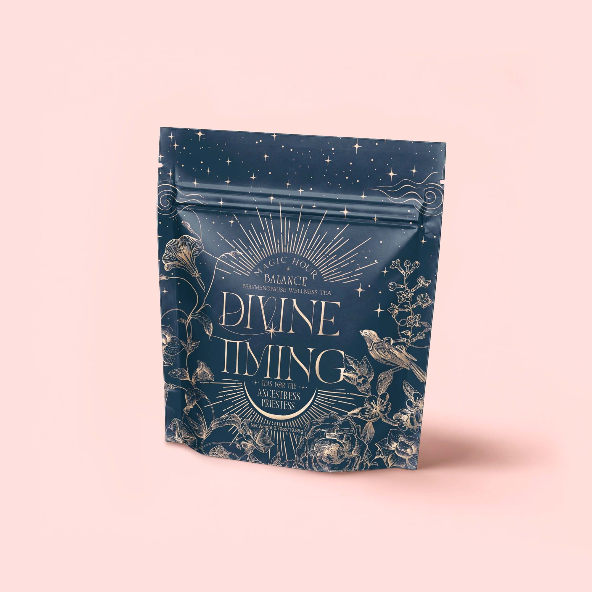 A dark blue pouch labeled "Divine Timing Balance" features gold celestial and floral illustrations, stars, and birds. Designed for women's wellbeing and menopause support, the packaging is set against a soft pink background.
