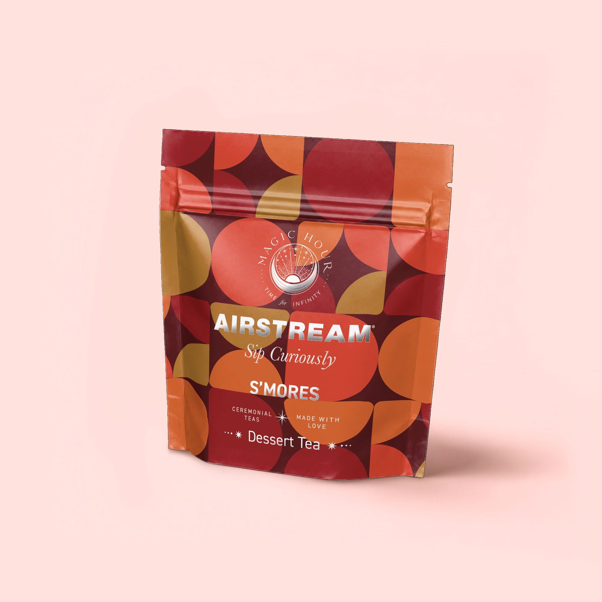 A resealable bag labeled "S'mores: Chocolate Herbal Dessert Tea for the Kid in All of Us" features organic rooibos in a caffeine-free blend, with an orange, red, and brown geometric pattern on light pink.