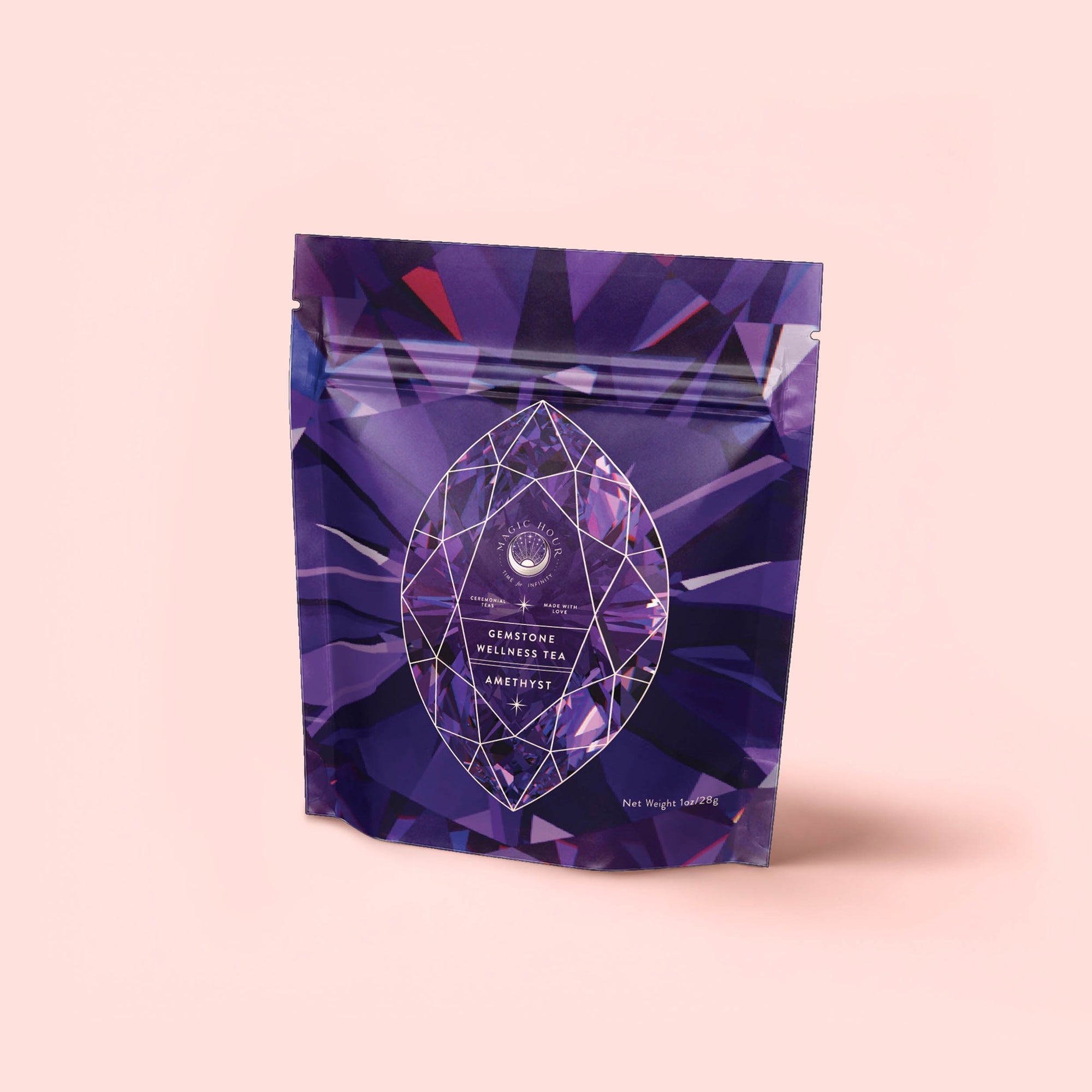 A purple, resealable pouch labeled "Amethyst: Strawberry-Passionfruit Gemstone Wellness Tea" with crystal designs stands upright on a light pink background—ideal for those seeking spiritual clarity with organic herbal tea.