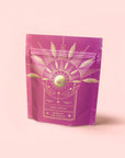 A pink and purple resealable pouch with gold leaf and orb designs is included in the Herbal Tea Sampler Tea Box: Caffeine-Free Teas for Sleep, Digestion & Immunity. Enjoy with a free tea strainer.