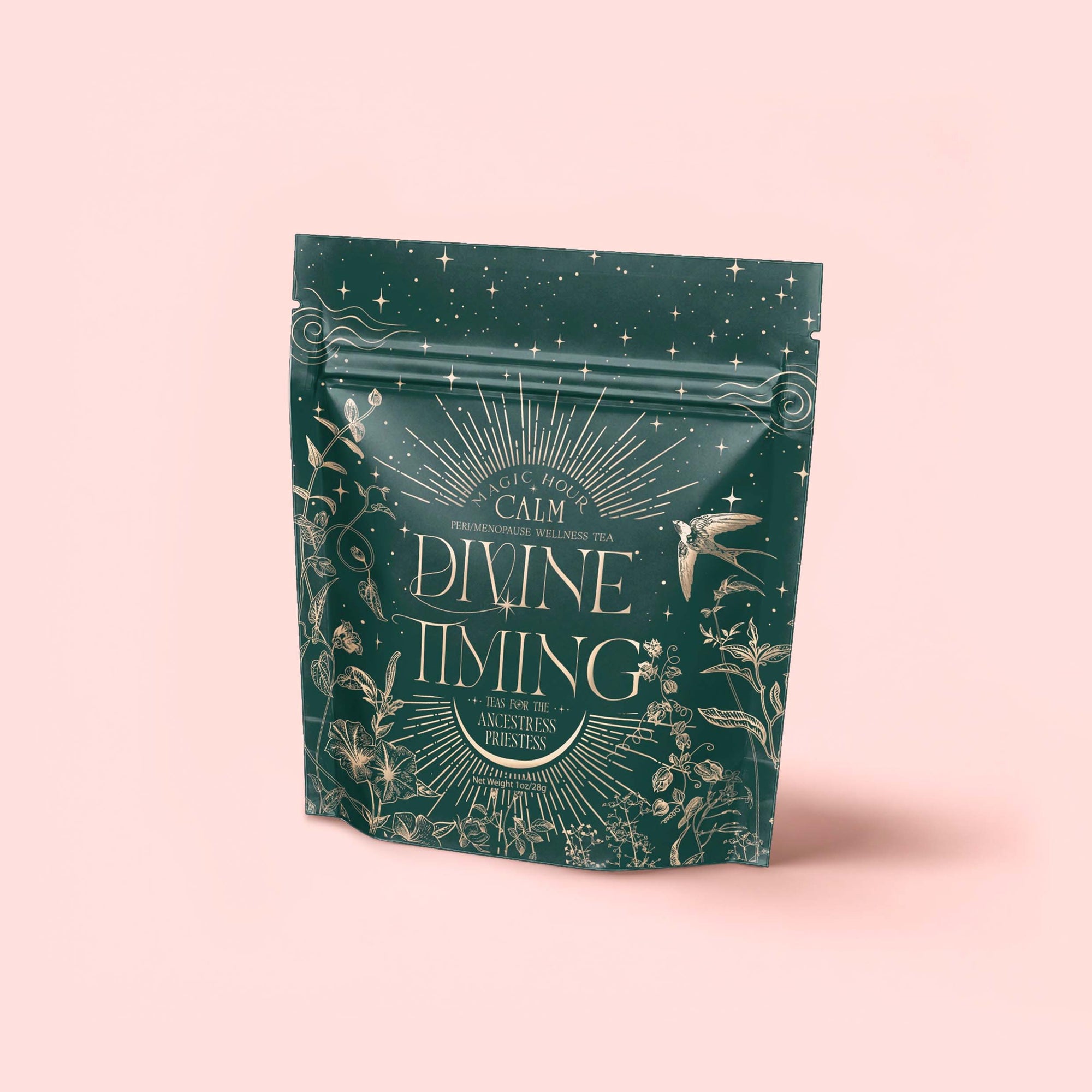 A green tea package labeled "Divine Timing Calm" features gold plant, star, and hummingbird illustrations on a pale pink background. This premium botanical wellness tea contains a cooling mint adaptogen blend for calm and emotional balance.