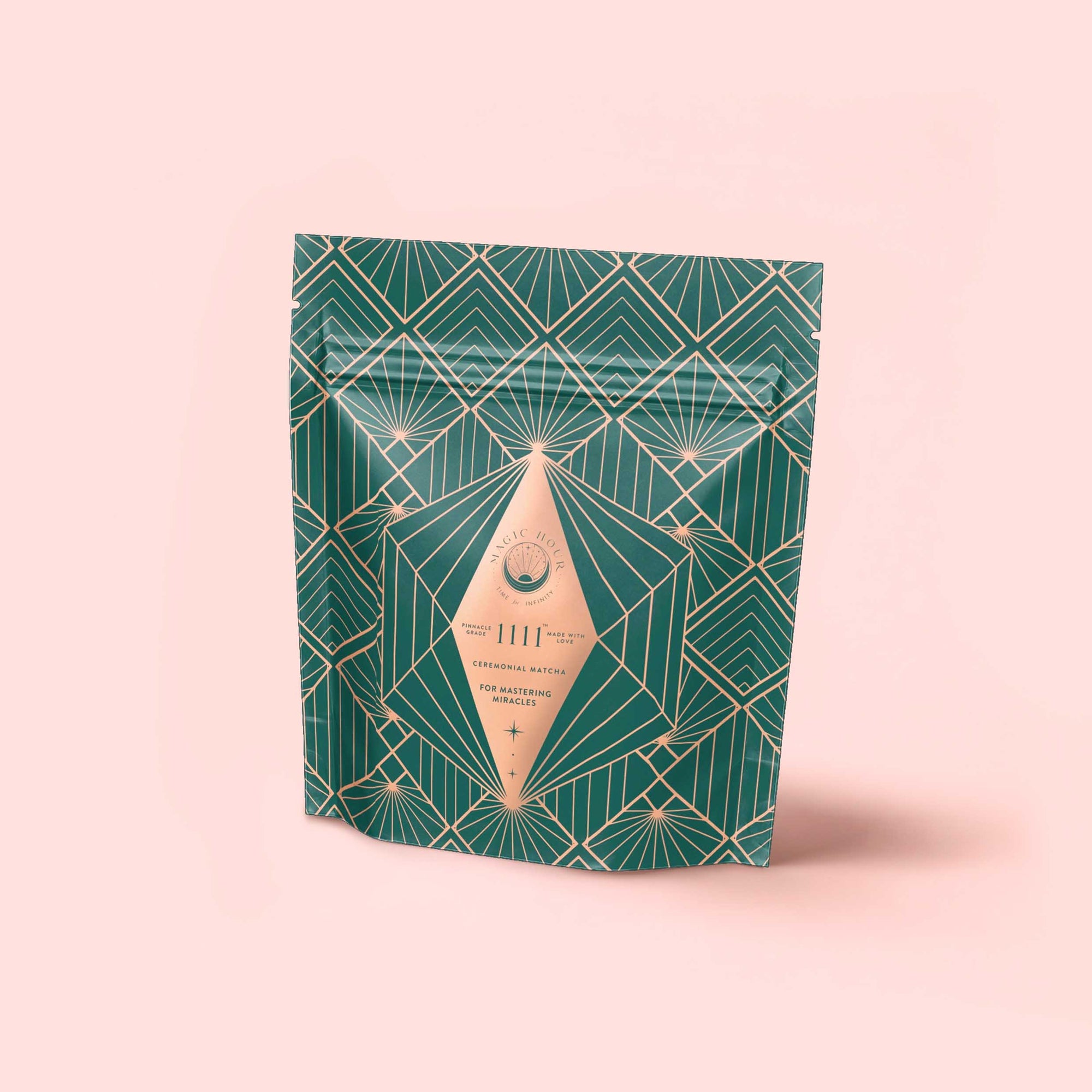A stand-up pouch with an art deco green and gold geometric pattern, featuring a diamond-shaped beige label reading "Matcha 1111: Highest Grade of Ceremonial Matcha," displayed against a light pink background.