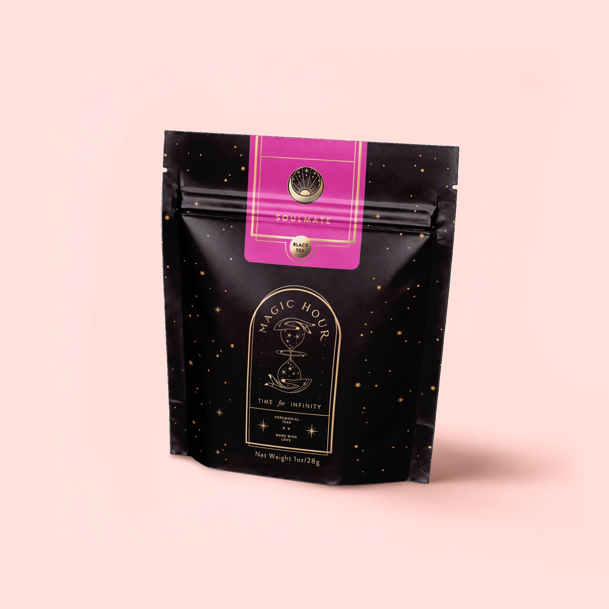 A black resealable pouch with gold star patterns and a pink label at the top features Magic Hour's "Soulmate: Chocolate-Raspberry-Rose Black Tea for Finding & Celebrating Love" against a light pink background.