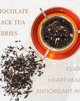 A cup of dark tea with a tea strainer on top, filled with organic, loose leaf tea. Next to the cup, scattered tea leaves. Text around the image reads: "CHOCOLATE, BLACK TEA, BERRIES, CLARITY, HEART HEALTH, ANTIOXIDANT-RICH." Magic Hour's Virgo Tea of Virtue, Wit & Meticulous Magic brings holistic benefits.