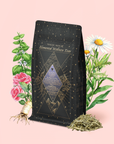 A tea bag labeled “Water White Tea: Soothing Lemon Balm Rose Reishi Tea for Going with the Flow” rests amid illustrated herbs, flowers, and loose tea leaves on a pink background, evoking a calming tea ritual perfect for relaxation.