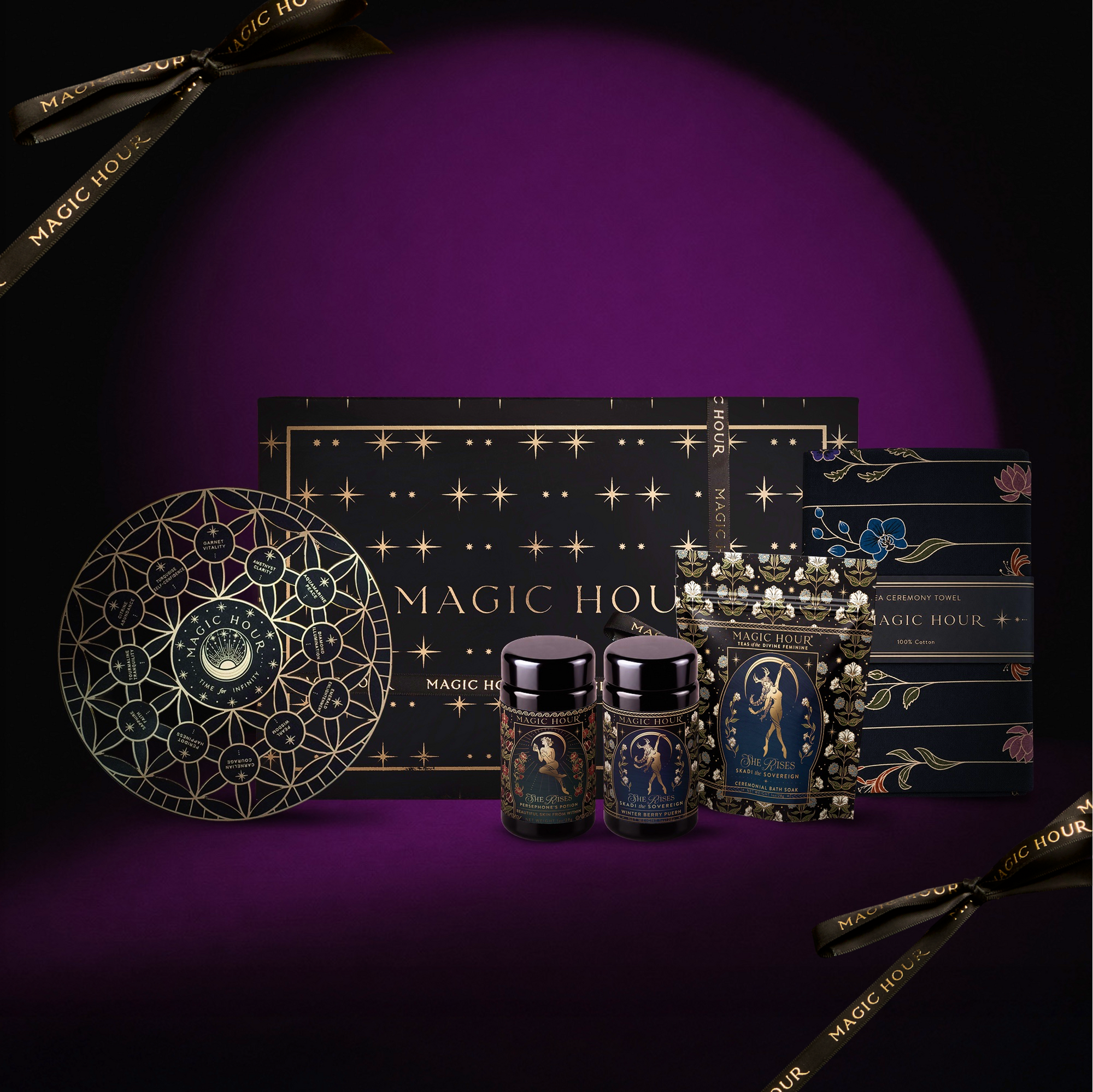 The Wild Woman Devotional Box is a luxurious tea gift set adorned with celestial and star motifs, featuring the indulgent Winter Berry Puerh, two jars, a tin, and a plate—all beautifully packaged against a deep purple background for an enchanting ritual experience.