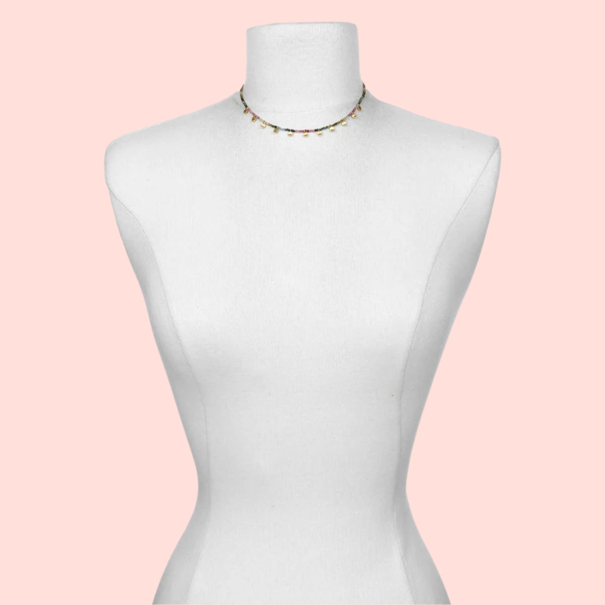The Tourmaline Gold Moon Choker Necklace, featuring minimalist colorful beads, is displayed on a white dress form mannequin against a simple white background.