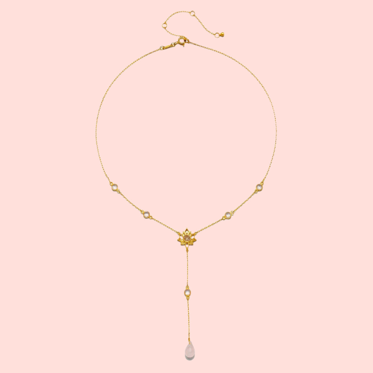 The Transformed by Love Lotus Lariat Necklace features a delicate 18k gold chain with small round accents and a single pink teardrop pendant, evoking rose quartz elegance in an exquisite lotus-inspired lariat design.