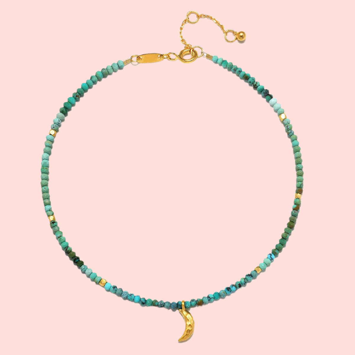 A delicate 9" turquoise moon anklet with small turquoise beads, gold accent beads, an adjustable gold clasp, a 1" extender chain, and a gold crescent moon charm—a timeless celestial accessory for any look.