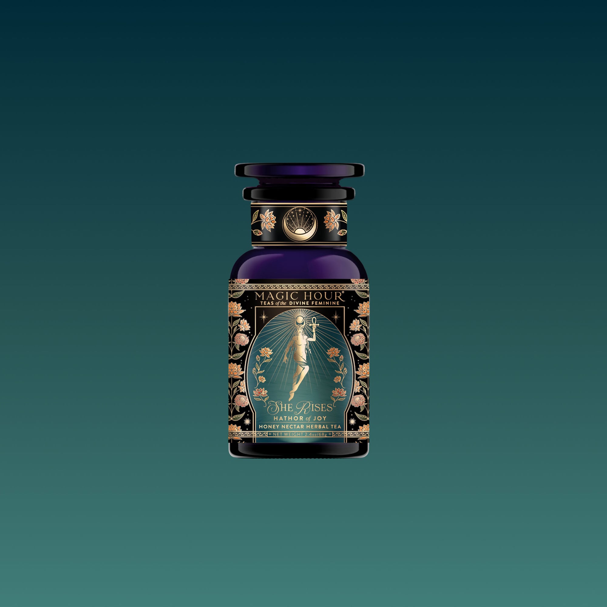 A dark glass bottle with an ornate label featuring a golden fairy and floral designs, labeled “Hathor of Joy: Honey Nectar Herbal Tea” against a gradient teal background.