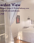 Experience The Soul of Tea: A Two Day Retreat in Ojai, CA. Enjoy a sunlit bedroom with a queen bed dressed in crisp white bedding and pillows, complemented by a wall lamp, framed artwork, billowy white curtains, and warm wooden floors. French doors open to reveal your own serene space—perfect for savoring peaceful tea moments. Reserve your soulful retreat now for $1,799.