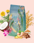 A vibrant teal bag of Tulum Horchata Chai, adorned with tropical bird art, sits amidst coconut, ginger, cinnamon, rice, flowers, and a bowl of brown sugar on a light pink backdrop—an inviting display hinting at an adaptogenic wellness blend designed to revitalize your senses.