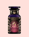 A decorative purple tea jar labeled “Monthly Magic Tea Journey Subscription” with an illustration of a goddess, floral patterns, and gold accents on a light pink background—perfect for elevating your goddess ritual tea experience or as an inspiring addition to your Divine Feminine journey.